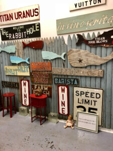 Farmers market the Velvet Mill displaying whale shaped wooden signs and other decorative signs.