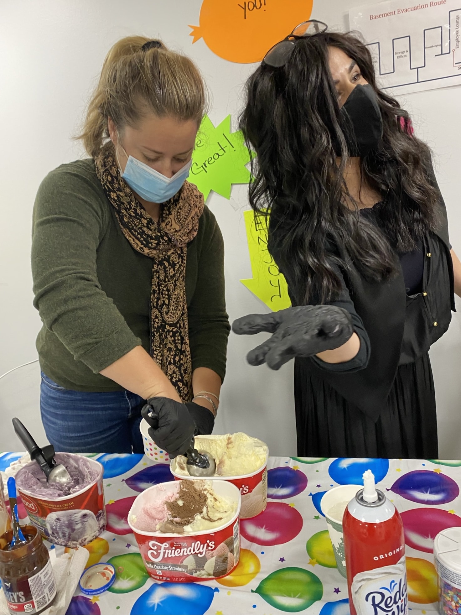 Two women scoop ice cream for housekeeping appreciation week
