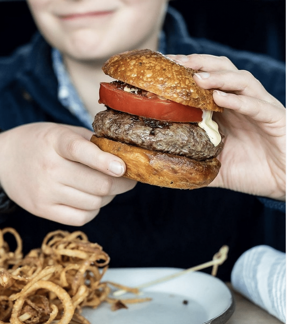 Mystic Restaurant Week participating boy holding up featured Big Girl Burger 