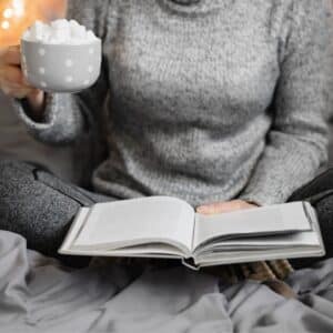 Women reading a book with hot cocoa