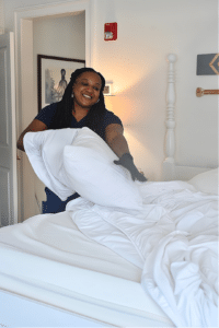 Housekeeper making bed in Hoxie House at The Whaler's Inn in Downtown Mystic