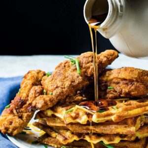 Fried Chicken and Waffles at Kitchen Little in Mystic with syrup being poured over.